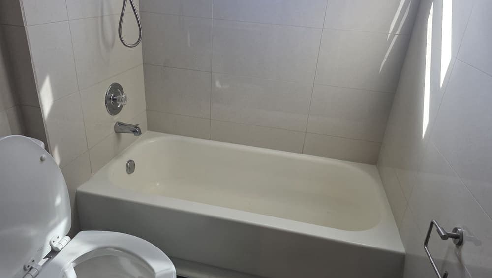 A bathtub and tile surround left clean, the enclosure free of soap film