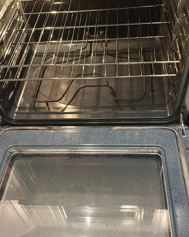 The same oven after cleaning, the racks, oven floor and door glass cleared of grease